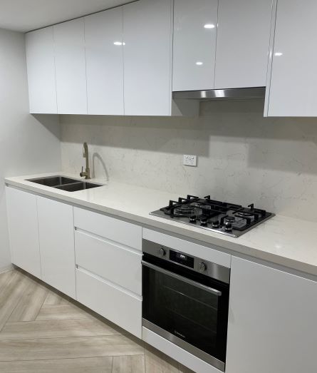 bathroom renovations sydney- a kitchen with white cabinets and a stove