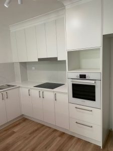 kitchen renovations- a kitchen with white cabinets and a stove