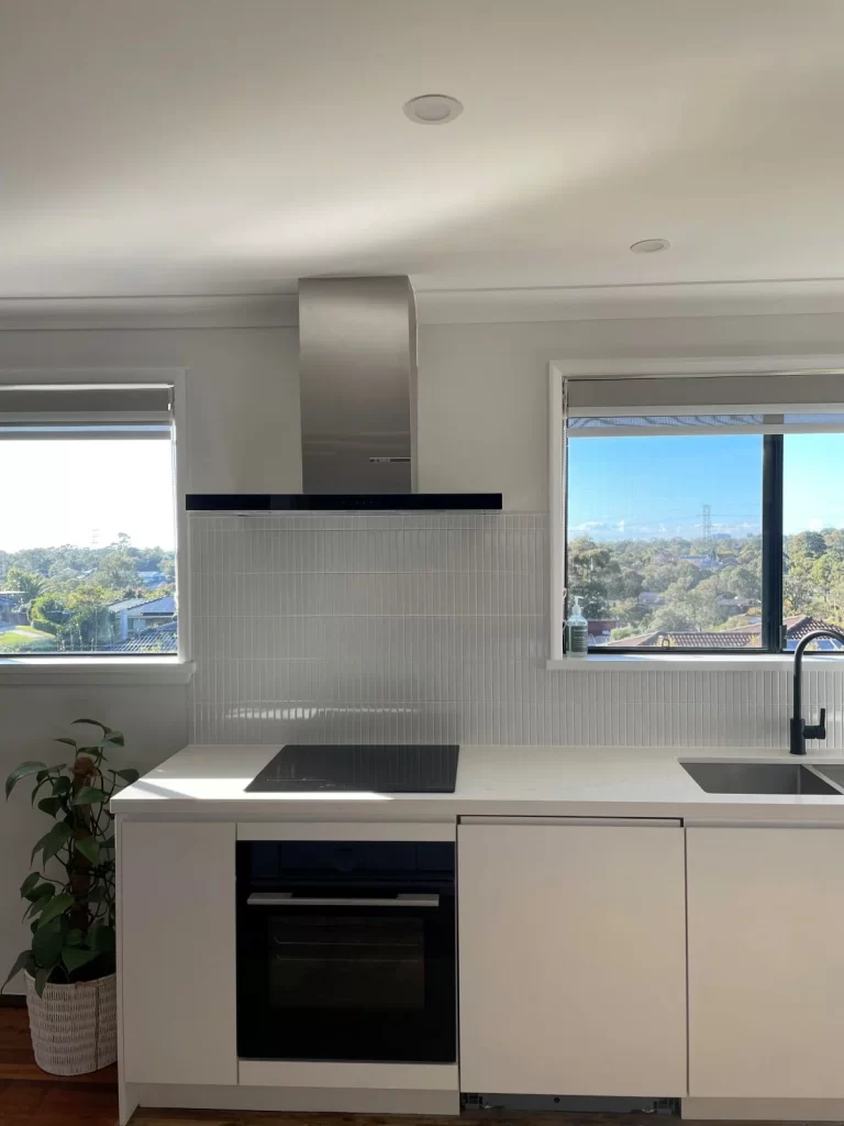 kitchen renovations- a kitchen with white cabinets and a black stove